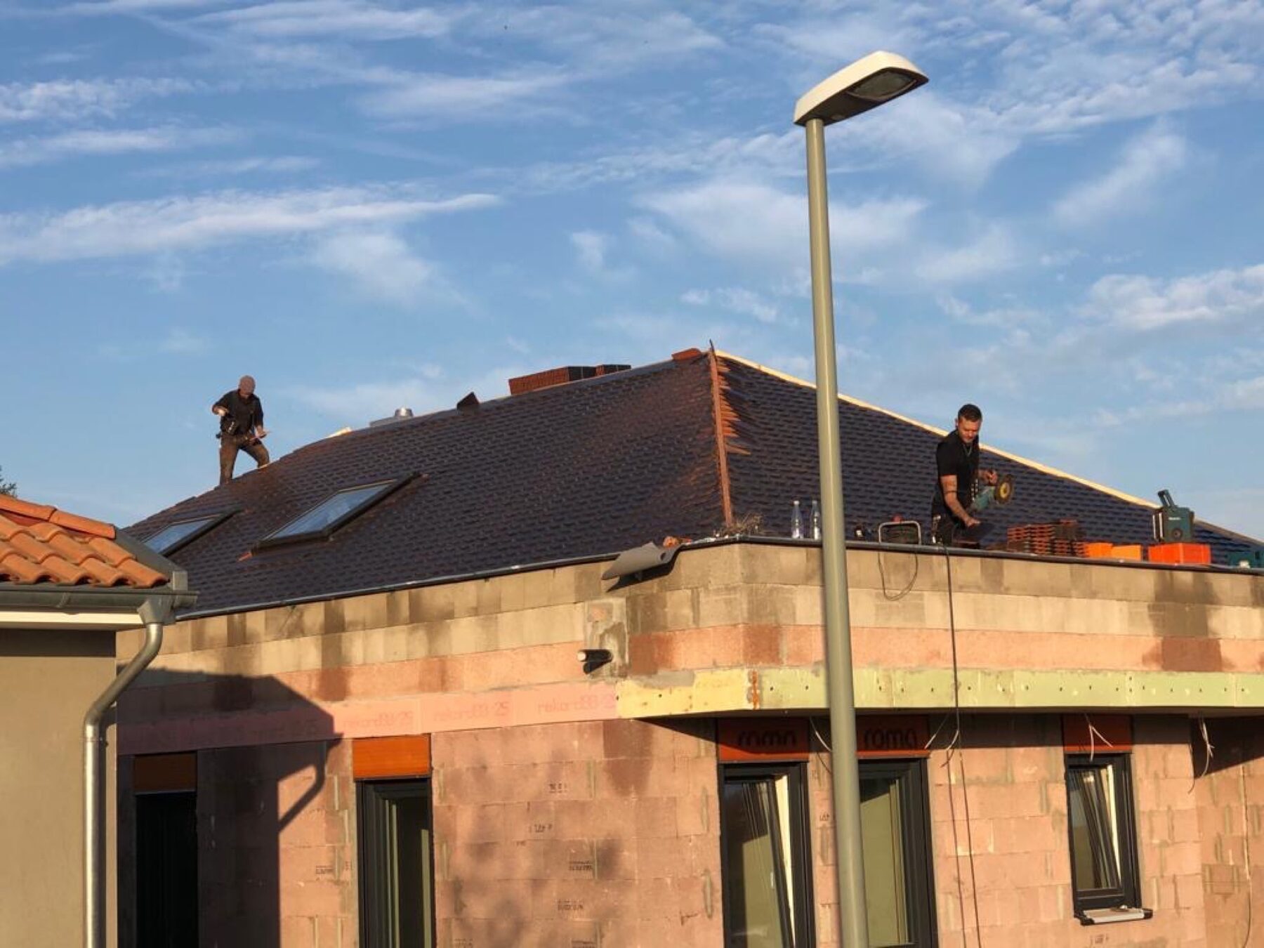 Bungalow Walmdach in der Abendsonne mit Mitarbeiter