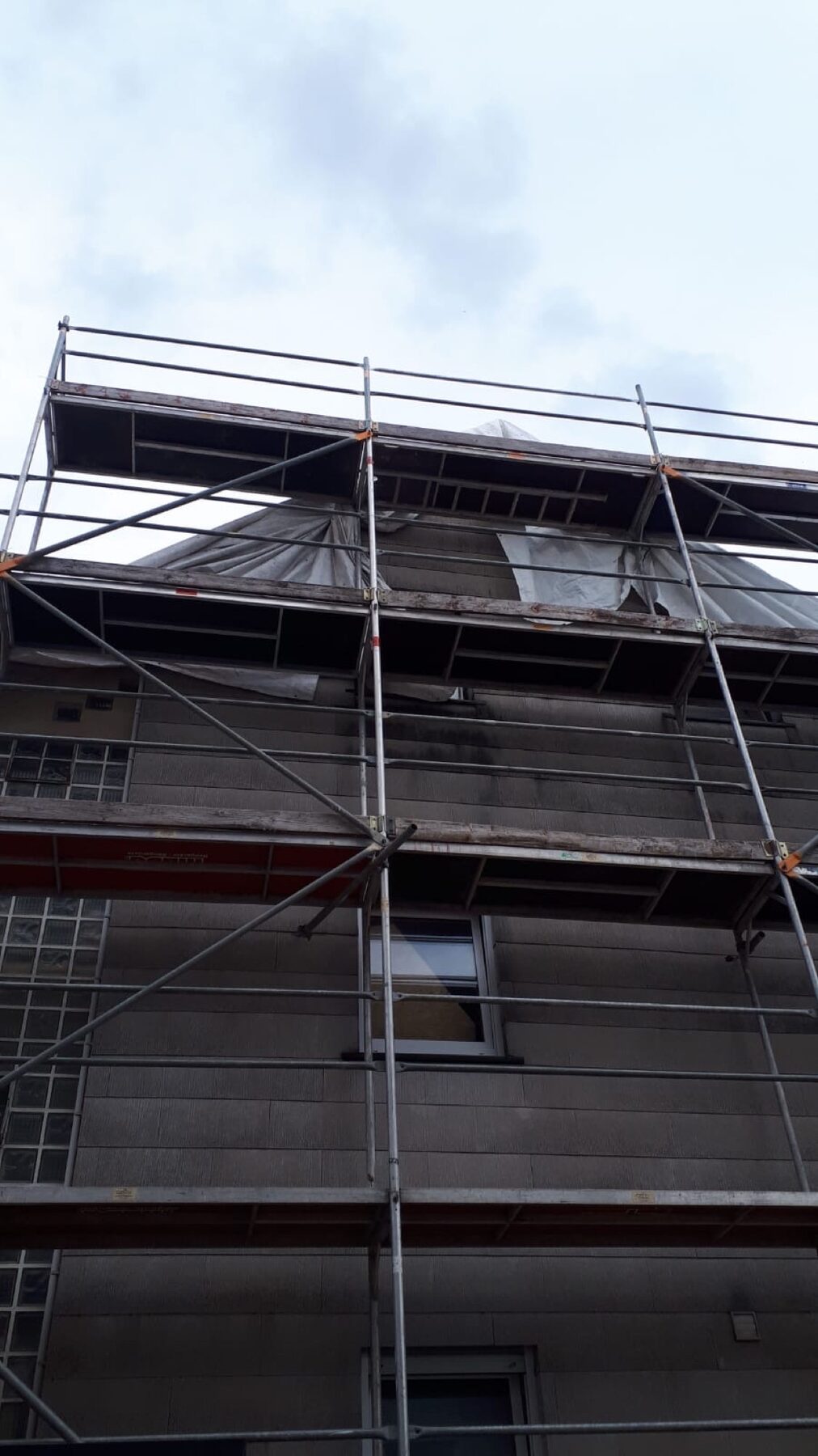 Fassade mit Gerüst und Plane aus der Untersicht